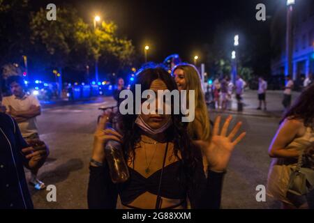 Barcelona, Catalonia, Spain. 18th July, 2021. People are seen being evicted by the police from Barceloneta beach.Catalonia has decreed the return of the curfew starting at 1:00 a.m., given the rebound in cases as a result of the delta variant of the coronavirus. After the closure of bars and nightlife, at the time that if the measure begins on that Sunday, July 18, the police have evicted crowds of people on the Barceloneta beach. (Credit Image: © Thiago Prudencio/DAX via ZUMA Press Wire) Stock Photo