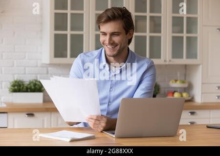 Excited millennial enterpreneur do paperwork at home office analyze report Stock Photo