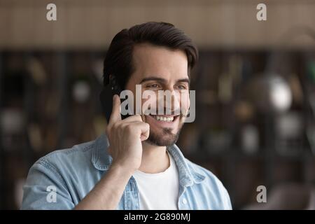 Sincere smiling young man holding telephone conversation. Stock Photo