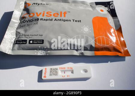 Covid-19 disease rapid antigen nasal testing kit. Testing done at home shows result with red pink stripe line single on C which says Negative . Packet Stock Photo