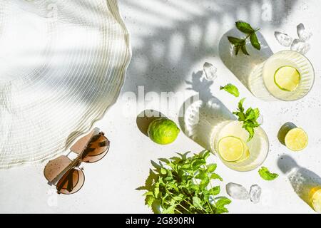 Tradition Summer drink cocktail mojito with ice, lime and mint on white with natural light and bright shadows. Top view