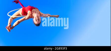 Outdoor activity of gymnast performing training on the hoop in the sky - Girl performing dancing and make acrobatic trick in the air, sports, active, Stock Photo