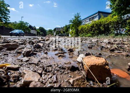 Hagen, Germany. 18th July, 2021. Water still runs down the torn up road into the valley. On the fourth day after the flood, the extent of the destruction becomes visible. Credit: David Inderlied/dpa/Alamy Live News Stock Photo