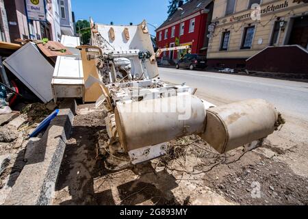 Hagen, Germany. 18th July, 2021. A treatment chair from a practice stands destroyed on the sidewalk. Residents have put the household effects destroyed by the flood on the sidewalk. The city administration can't cope with the removal because of the quantity. Credit: David Inderlied/dpa/Alamy Live News Stock Photo