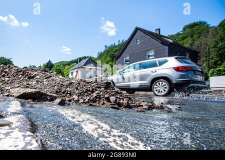 Hagen, Germany. 18th July, 2021. Mountains of stones and debris lie on a road over which residual water still runs. On the fourth day after the flood, the extent of the destruction becomes visible. Credit: David Inderlied/dpa/Alamy Live News Stock Photo