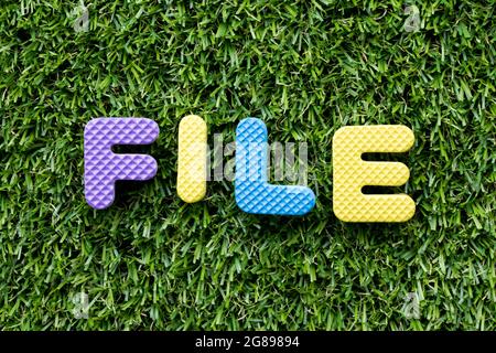 Color alphabet letter in word file on artificial green grass background Stock Photo