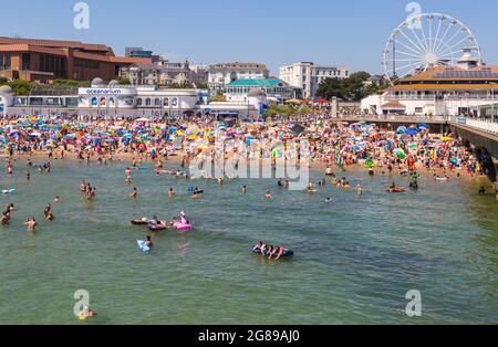 Bournemouth, Dorset UK. 18th July 2021. UK weather: hot sunny day at Bournemouth beach on the South Coast, as crowds flock to the seaside and sunseekers enjoy the sunshine in the heatwave. Beaches are packed with barely a spare space and car parks full.  Credit: Carolyn Jenkins/Alamy Live News