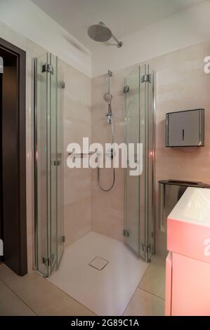 Glance into a very small bathroom with a special solution for the shower enclosure to create more space Stock Photo