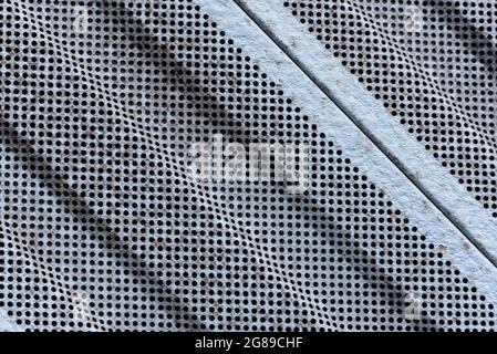 Perforated, painted and dirty sheet metal, the background of an industrial style. Stock Photo