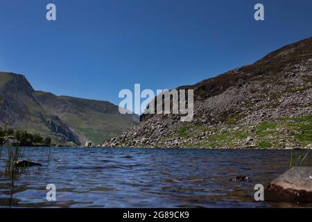 Llyn Ogwen, Ogwen lake, with views of the mountains of Snowdonia National Park, North Wales.  On a summers day with blue sky Stock Photo