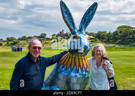 Senior couple with colourful giant hare sculpture, The Big Hare Trail event, North Berwick, East Lothian, Scotland, UK Stock Photo