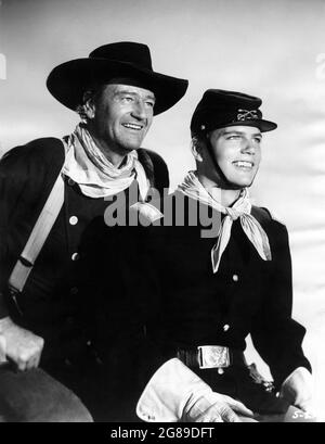 JOHN WAYNE and his son PATRICK WAYNE Publicity Portrait in THE SEARCHERS 1956 director JOHN FORD novel Alan Le May screenplay Frank S. Nugent music Max Steiner executive producer Merian C. Cooper  C.V. Whitney Pictures / Warner Bros. Stock Photo