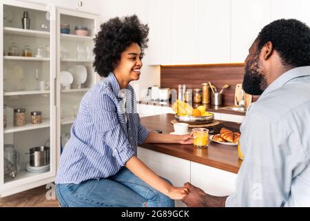 Beautiful afro american couple having breakfast together at home - Cheerful black couple spending time together in the morning Stock Photo