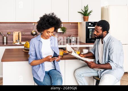 Beautiful afro american couple having breakfast together at home - Cheerful black couple spending time together in the morning Stock Photo