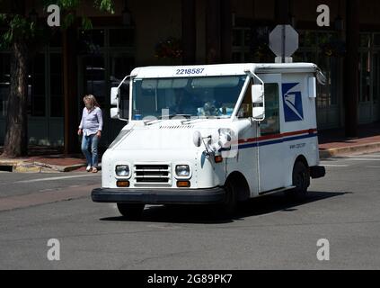 A mail truck, a Grumman Long Life Vehicle, used by the United States Postal Service drives down a street in Santa Fe, New Mexico. Stock Photo