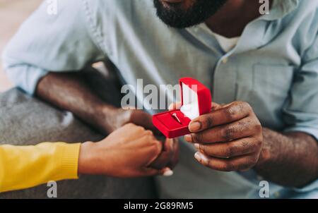 Black couple drinking sparkling wine at home to celebrate - Cheerful couple bonding and having aperitif Stock Photo