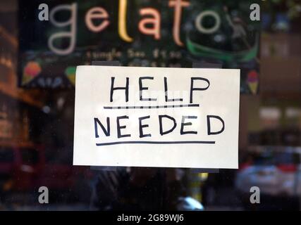 A Help Wanted sign taped to the windwo of a ice cream and gelato parlor and cafe in Santa Fe, New Mexico. Stock Photo