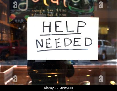 A Help Wanted sign taped to the windwo of a ice cream and gelato parlor and cafe in Santa Fe, New Mexico. Stock Photo