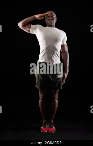 African american man greeting at camera with a military salute in studio Stock Photo