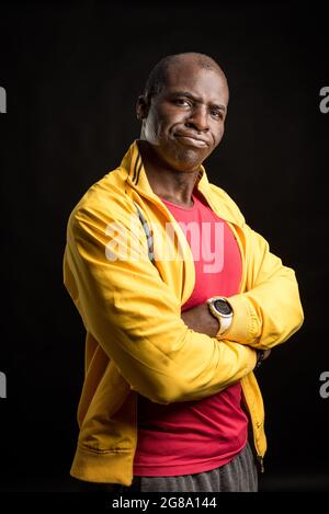 Portrait of a black man with crossed arms standing looking at the camera Stock Photo