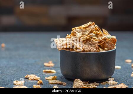 Dry muesli in a saucer on the background of a stone table top. Healthy food and light diet breakfast concept, copy space Stock Photo