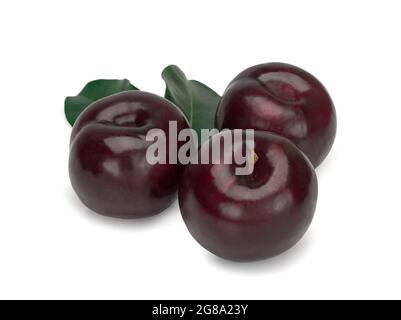 Three plums with leaves on white background Stock Photo