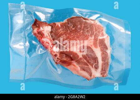 pork steak in vacuum packed sealed for sous vide cooking on blue background Stock Photo