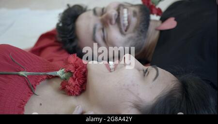 An Indian couple lying on a bed and spending a great time - first night concept Stock Photo