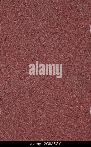 Red rubber floor, texture, background. Relief surface. Faded, old, granular rubber coating and surface with blurry chaotic pattern. Embossed patterns Stock Photo