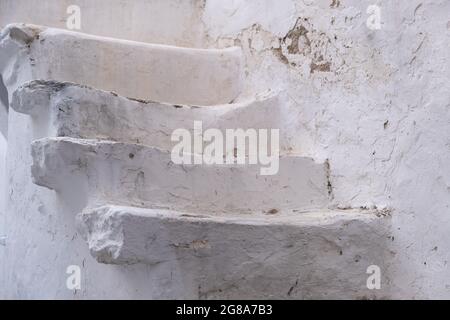 Stairs on exterior white building wall, Greek island Cyclades architecture, Stone whitewashed steps clloseup view Stock Photo
