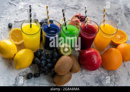 a set of cool fresh squeezed juices or cocktails in a glasses made from orange, kiwi, lemon, grapes, pomegranate Stock Photo