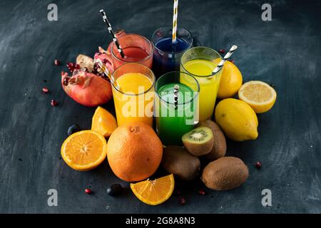 a set of cool fresh squeezed juices or cocktails in a glasses made from orange, kiwi, lemon, grapes, pomegranate Stock Photo