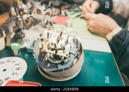 Close up on clockwork of clock to be repaired in watchmaker workshop Stock Photo