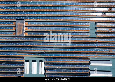 Solar panels on the roof of a large industrial building. Stock Photo