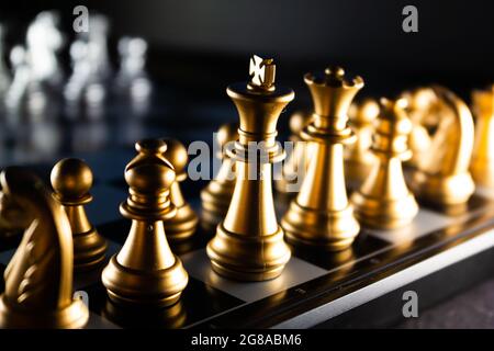 A horizontal shot of cool gold chess pieces in the starting position Stock Photo