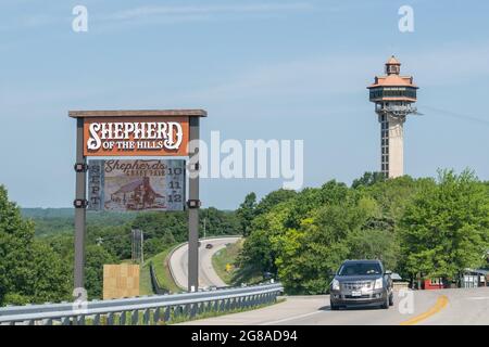 Branson, MO - June 12, 2021: Sign for Shepherd of the Hills, with Inspiration Tower in the background. The tower is located on Inspiration Point Stock Photo