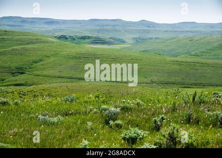 Vehicles travel Interstate 90 near Story, Wyoming, with wagon ruts of the old Bozeman Trail clearly visible on the hillside in the middle distrance. Stock Photo