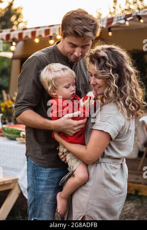 Family travel on vacation in camper van. Parents enjoy bond with little kid on trip in mobile home Stock Photo