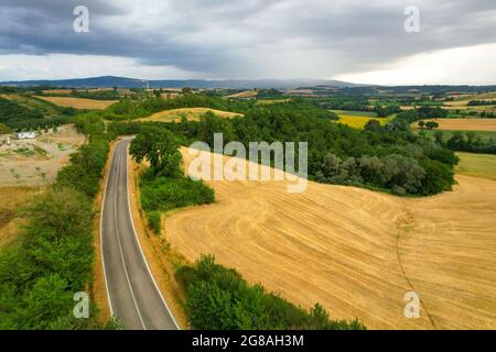 Beautiful idyllic summer or autumn landscape of Toscana with hills, forest trees and agricultural fields. Quiet cloudy evening before the rain Stock Photo