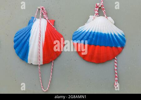 Camino de Santiago (Way of Saint James). Scallop shells decorated with the colours of French and Russian national flags on sale in a souvenir shop near the village of A Tellada in Galicia, Spain. The French route of the Camino de Santiago goes through this village on the way from Barbadelo to Portomarín. The scallop shell, also known as the Shell of Saint James is a traditional symbol of the pilgrimage to Santiago de Compostela. Stock Photo