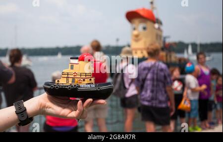 Hamilton Canada. 18th July 2021. A visitor displays a toy of Theodore Too as the tugboat Theodore Too arrives at the Port of Hamilton in Hamilton Ontario Canada on July 18 2021