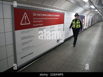 London, UK. 18th May, 2020. A police officer patrols the London Underground after the government rules that only passengers undertaking essential travel should use the tube system, during the covid 19 restrictions period.After more than a year of restrictions for travellers' mandatory face mask wearing and social distancing will end (on Monday 19th July). The government has still advised the wearing of face masks and allowing extra space in crowded spaces indoors. (Photo by Martin Pope/SOPA Images/Sipa USA) Credit: Sipa USA/Alamy Live News Stock Photo