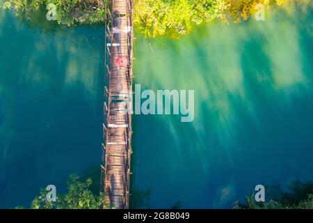 Nice wooden bridge across green lake in Moc Chau district northern Vietnam Stock Photo