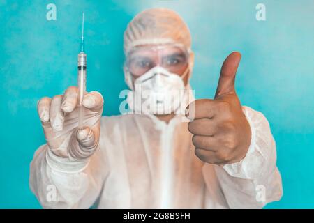 Close up of scientist interacting with syringe liquid vaccine in laboratory. doctor is showing the thumbs up. The concept of correct vaccination, bene