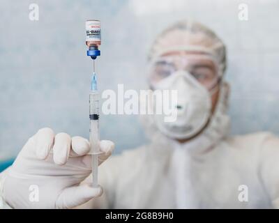 COVID-19 vaccine in researcher hands, male doctor holds syringe and bottle with vaccine for coronavirus cure. close up Stock Photo