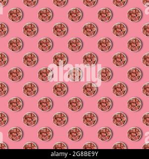 Repeated Ceramic bowl with raw marinated meat on pink background. Pieces of pork with salt, pepper and granulated garlic. Food, ingredients. Flat lay Stock Photo