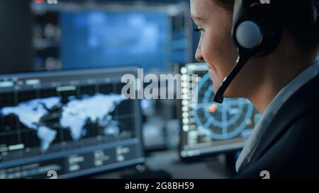 Computer Screen with Global Map Technology Used by a Female Flight Controller in a Mission Control Center Room with Other Scientists. Team of Stock Photo