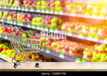 Supermarket grocery table background with cart. Food and groceries blurred on store shelves. High quality photo Stock Photo