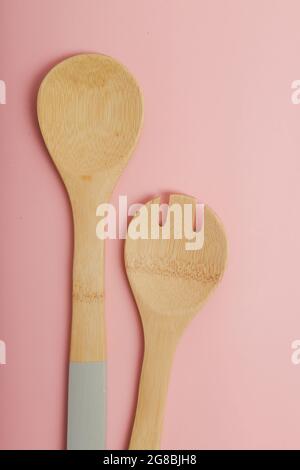 set of wooden kitchen spoons on pink background Stock Photo