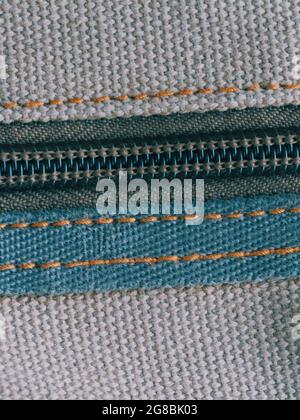 A zipper, zip, fly, or zip fastener, known as a clasp locker, is a commonly used device for binding the edges of an opening of fabric. Close-up. Stock Photo